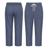Uk Scrub Supply A pair of scrub pants shown from the front and back, in a slate blue color. The front view shows a white drawstring at the elastic waistband and two front patch pockets.