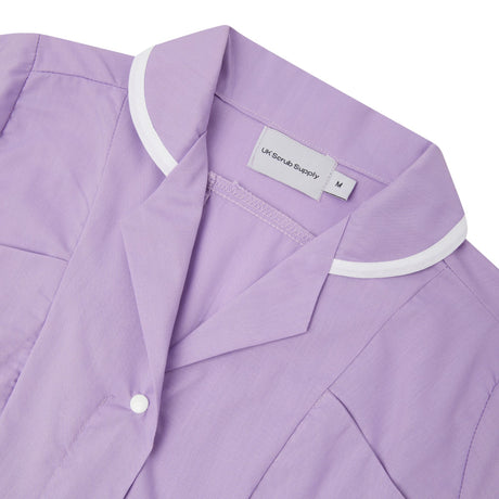Close-up of a lilac shirt with white trim and label.
