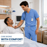 Uk_Scrub_Supply_Blue_Color_Scrub_Trouser A healthcare worker in blue scrubs uses a stethoscope on a patient lying in a hospital bed. The scene is set in a bright, modern hospital room with medical equipment and a window.