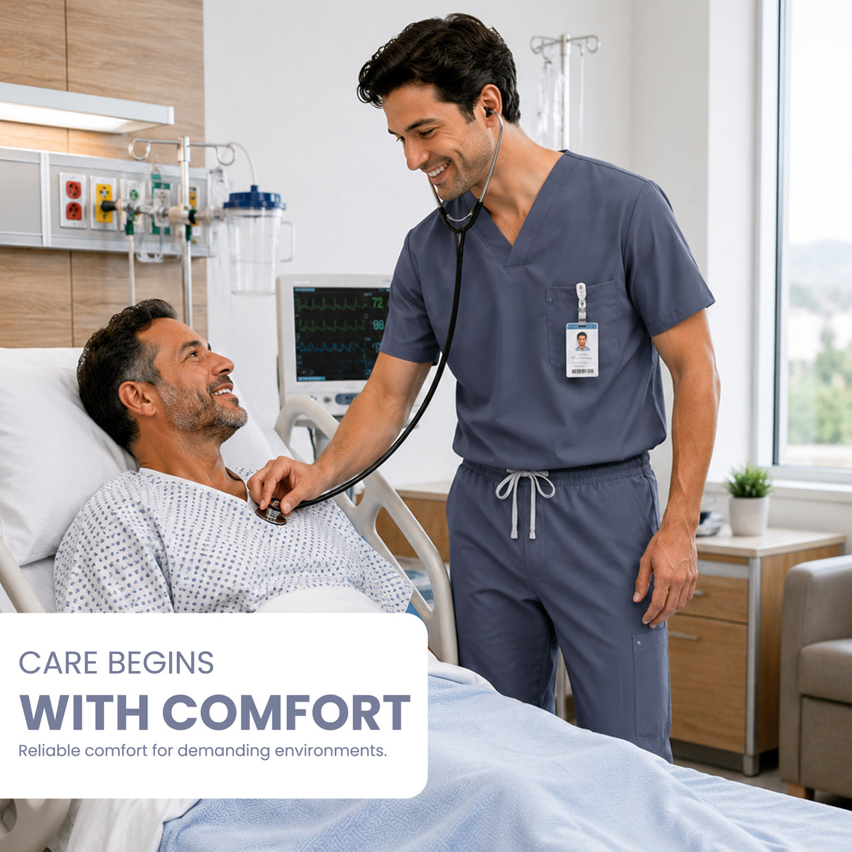 Uk_Scrub_Supply_Navy_Color_Scrub_Trouser A male healthcare worker in navy blue scrubs smiles while holding a stethoscope to a patient's chest in a bright hospital room. The patient is lying in a bed, smiling.