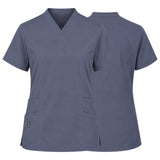 A women's short-sleeve V-neck scrub top shown from both the front and back views. The scrub top is a solid slate blue color with two front patch pockets, one of which has a metal snap button closure.