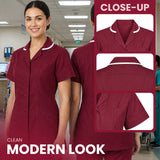 A woman wearing a burgundy short-sleeve scrub top with white piping trim, shown in a hospital hallway. The right side includes close-up inset views of the collar, back, and pocket details, with text reading 'CLOSE-UP' and 'CLEAN MODERN LOOK'.